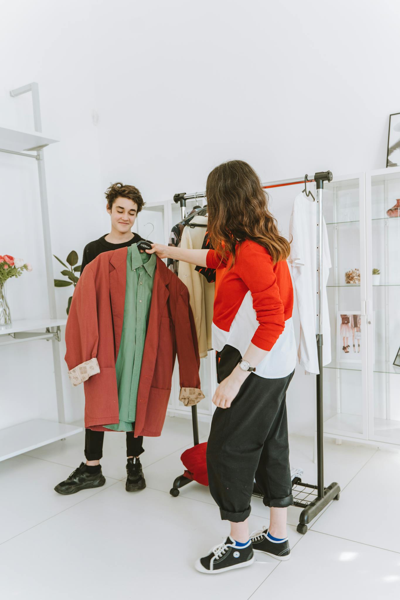 Two adults engaging in selecting trendy clothes in a modern boutique interior.